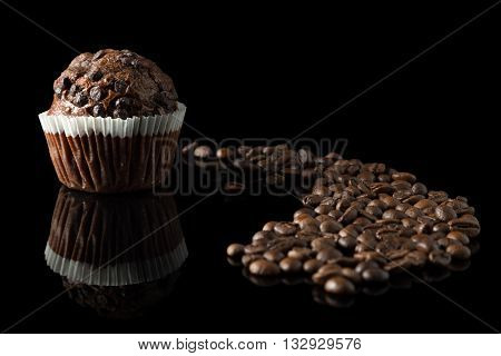 chocolate muffin with coffee on black with reflection