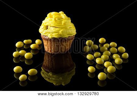 one yellow muffin on black with reflection