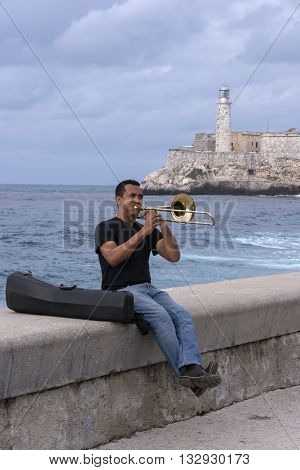 Havana, Cuba - January 20, 2016: A man playing the trumpet in the Malecon of Havana in Cuba