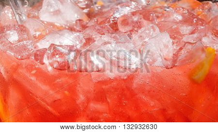 Background of red drink with lemon and ice