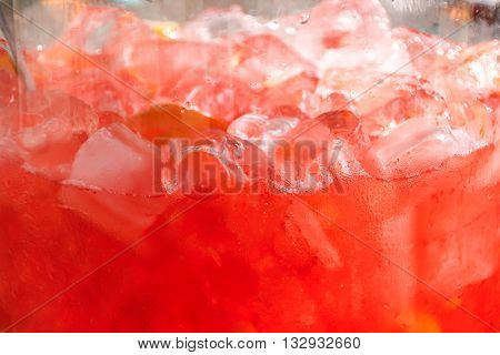 Background of red drink with lemon and ice