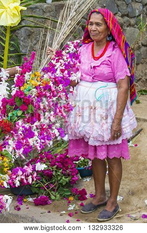 PANCHIMALCO EL SALVADOR - MAY 08 : A Salvadoran woman decorates palm fronds with flowers during the Flower & Palm Festival in Panchimalco El Salvador on May 08 2016