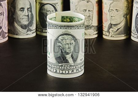 President with bills two dollars on a background of presidents from other denominations