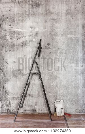 Old Concrete Wall In Repairing Room With Dirty Floor,tools And Stepladder