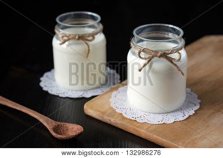 natural yogurt in a jar on the dark background