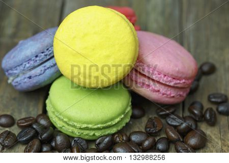 colourful french macaroons and coffee bean on wooden table