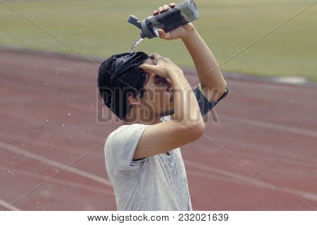 Vintage Toned Image Of Healthy Young Asian Runner Pouring Water With Waterbottle On His Face After R