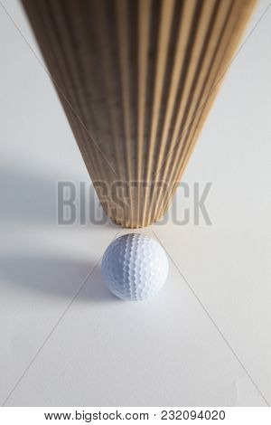 Corrugated Brown Paper Roll And Golf Ball On The White Desk. Exclamation Mark.