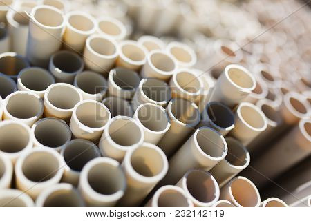 New Plastic Water Pipes Laid In A Stack In The Warehouse. Plumbing And Water Supply. Abstract Backgr