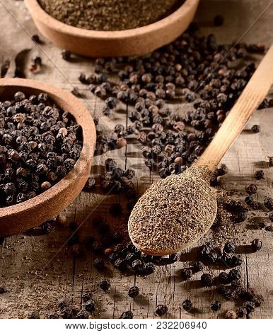 Black Ground Pepper In A Wooden Spoon On A Wooden Background.rustic Style