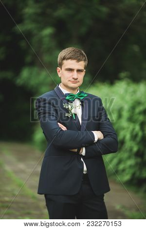 Happy Handsome Smiling Groom Posing With Boutonniere.