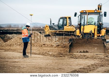 Construction Industry Details With Surveyor Using Gps System And Total Station. Engineer And Geodesy
