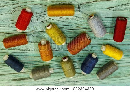 Set Of Multicolored Threads For Sewing And Embroidering On A Wooden Background. Hobbies, Clothes Rep