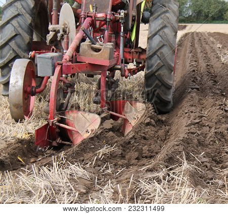A Vintage Tractor Ploughing A Straight Line Furrow.