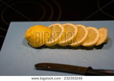 Fresh Juicy Lemon. Slice Thin Slices On A Cutting Board With Knife