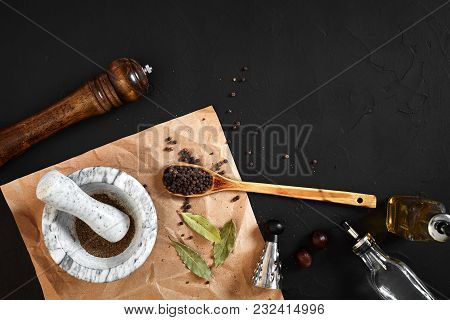 White Mortar And Pestle With Dried Peppers In Flat Lay On Black Background. Copy Space. Still Life. 