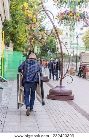 Artist On Day Street Carries Paintings, For Editorial Use