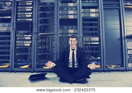 young handsome business man in black suit and tie practice yoga and relax at network server room while representing stres control concept