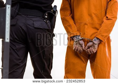 Cropped Image Of Prison Guard Leading Criminal In Handcuffs
