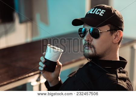View Of Prison Guard Holding Cup Of Coffee