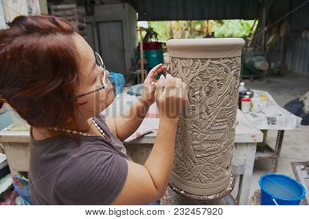 Kuching, Malaysia - August 27, 2009: Unidentified Woman Cuts Traditional Tribal Tattoo Motives Decor