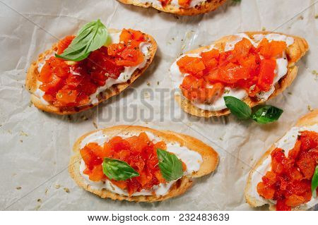 Italian Bruschetta On A Wooden Board With Feta Cheese And Herbs