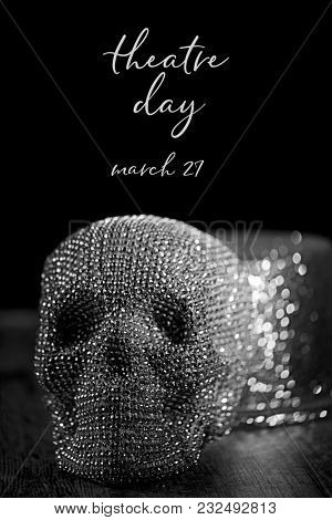 closeup of a sparkly skull and and a sparkly top hat, and the text theatre day march 27 against a black background