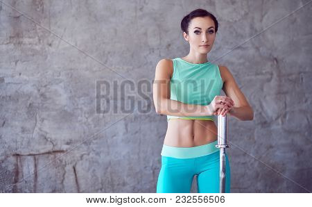 Portrait Of Athletic Female In Azure Sportswear Holding Berbell.