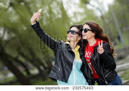 Two Pretty And Happy Young Woman Taiking Selfie With Mobile Phone In The Park. Best Friends Concept