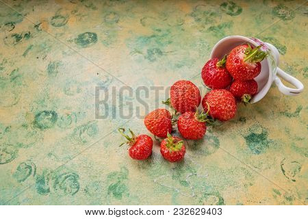 Strawberries Spilled From A Cup.fresh Strawberries In The Mug Isolated On Green Yellow Table. Berrie