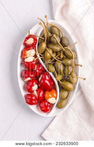 Stuffed With Cheese Small Peppers And Capers Divided Plate On Light Background