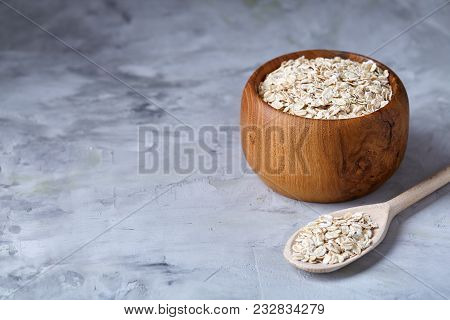 Oat Flakes In Bowl And Wooden Spoon Isolated On Dark Wooden Background, Close-up, Selective Focus, S