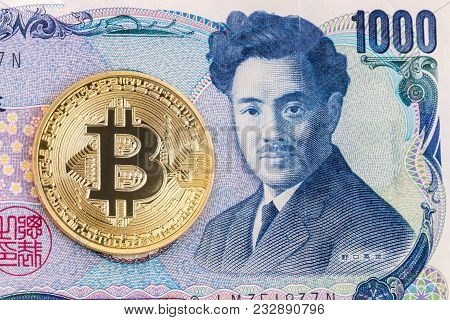 Close-up Of A Golden Bitcoin On 1000 Yen Banknote Background