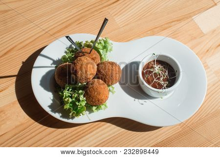 Closeup Of White Plate With Spanish Croquettes With Veal Meat And Mushrooms Served With Salad And Sa