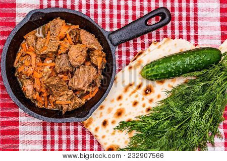 Top View Frying Pan With Delicious Beef Stew, Greenery, Fresh Cucumber And Bread