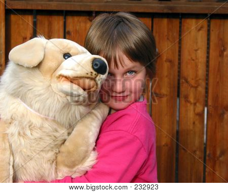 Niña con un perro de juguete grande