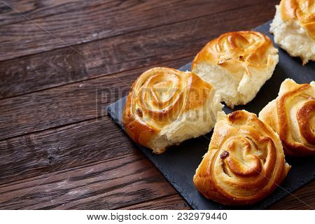 Homemade Rose Buns With Raisins On Wooden Cutting Board Over Rustic Vintage Background, Close-up, Sh