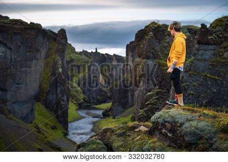 Young Hiker Standing At The Edge Of The Fjadrargljufur Canyon In Iceland. Fjadrargljufur Canyon Is A