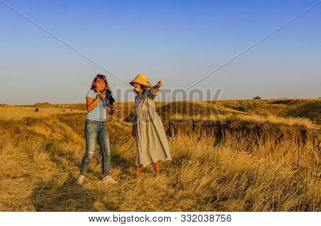 Ukraine, Kherson Region, September 6, 2019 Amazing Girl In A Developing Hat At Sunset In The Steppe 