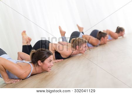 Group Of Young Sporty Sexy Women In Yoga Studio, Practicing Yoga Lesson With Instructor, Forming A L