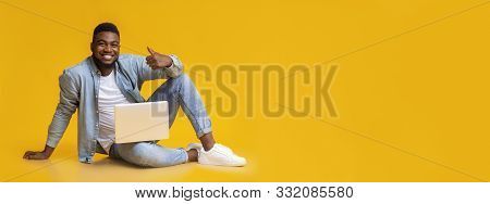 Cool Website. Smiling Black Millennial Guy Sitting With Laptop On Floot And Gesturing Thumb Up On Ye