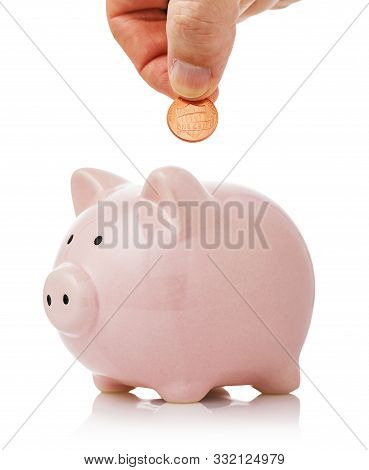 Hand Puts One Cent Into The Piggy Bank. Concept On Topic Of The Savings