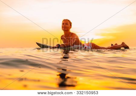 Attractive Surfer Woman On A Surfboard In Ocean. Surfgirl At Sunset