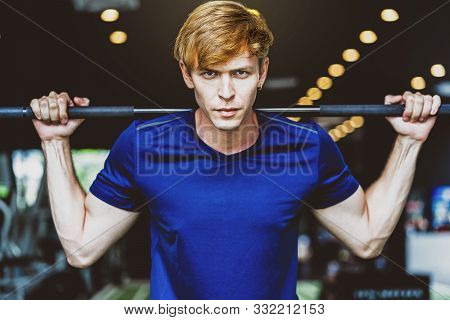 Young Man Wearing Sportswear Doing Excecise With The Bar In Gym Fitness Sport Complex, Posture Posit