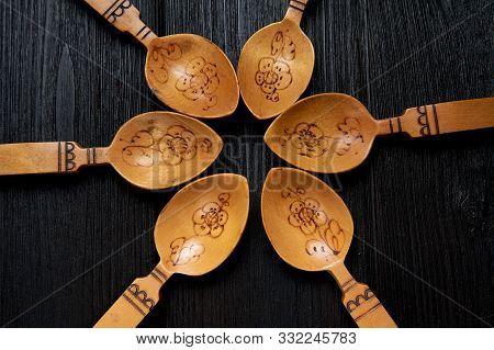 Old Russian Wooden Spoons With Hand Engraving And Pattern On A Black Wooden Background