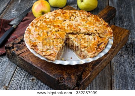 Traditional apple jalousie cake offered as closeup in a backing form on an old rustic wooden board 