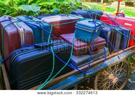 Old Luggage Cart Filled With Suitcases That Are Secured By A Rope, Nostalgic Baggage Transportation