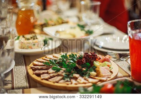 A Meat Plate Next To A Glass Of Red Juice. Table Decor At A Banquet. Celebration In The Restaurant.