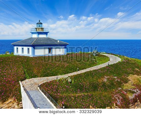 Summer Ocean Island Pancha Coastline Landscape With Lighthouse And Pink Flowers (spain).