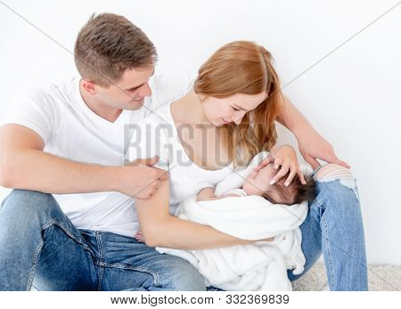 Father, mother and sleeping baby girl at home